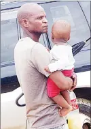  ?? ?? A man carrying a child along with marula brew at Buhleni Royal Residence.