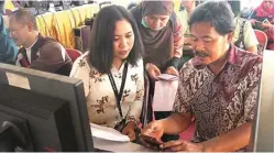  ?? GALIH ADI/JAWA POS ?? BERI PENGARAHAN: Staf KPP Pratama Gubeng, Ayu Rachmawati Effendi (kiri), memandu Joko Hermanuadi untuk pelaporan SPT tahunan melalui sistem online kemarin.