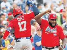  ?? AP PHOTO ?? World team Yusniel Diaz, of the Los Angeles Dodgers, left, celebrates his home run with World team manager David Ortiz in the seventh inning of the All-Star Futures baseball game against the U.S. team on Sunday at Nationals Park, in Washington. The...