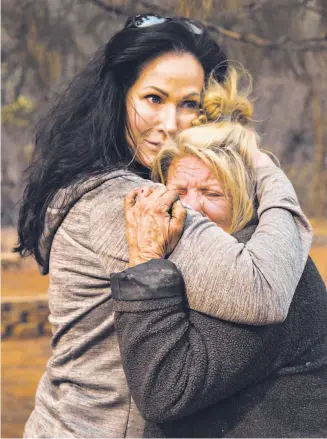  ?? Jessica Christian / The Chronicle ?? Animal volunteer evacuator Tamara Houston (left) consoles Cathy Fallon outside Fallon’s home after the Camp Fire destroyed much of the placid rural town of Paradise.