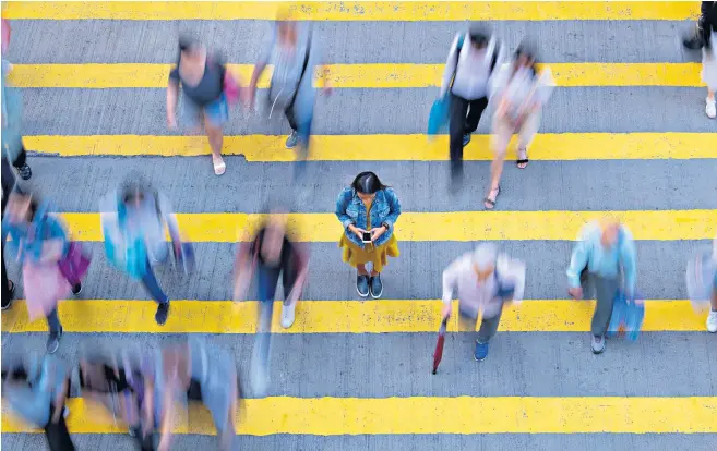  ??  ?? People distracted by their phone while walking in a crowd are less aware of pedestrian­s around them, which can lead to collisions, a study has shown