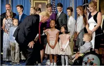  ?? PHOTO: REUTERS ?? US President Donald Trump greets families who he said had been negatively affected by the Affordable Care Act, in the Blue Room of the White House yesterday.