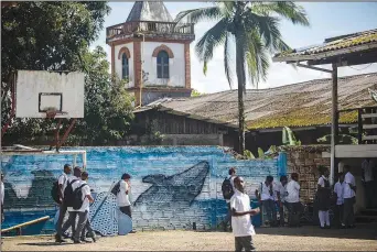  ?? (AP/Ivan Valencia) ?? A mural of a humpback (above photo) whale graces a wall of the Luis Lopez de Mesa school on Aug. 29 in Bahia Solano, Colombia. (Top photo) Male humpback whales compete for a female Aug. 29 in the waters of Bahia Solano.