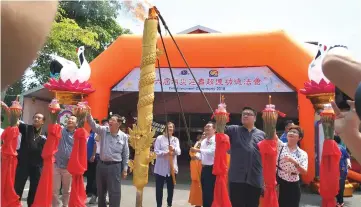  ??  ?? Chong (third right), Wong (fourth right) and Siaw (second right) light a giant joss stick during the Enlightenm­ent Ceremony.