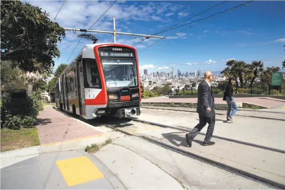  ?? Photos by Paul Kuroda / Special to The Chronicle ?? Reid Carter and Youjin Jung disembark from one of the new Muni light-rail cars at Mission Dolores Park along the J-Church line on Monday