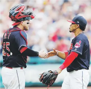  ?? Ap / ron schwane ?? Roberto Pérez (izquierda), quien sacudió un jonrón en el triunfo de Cleveland, saluda al también boricua Francisco Lindor luego de que los Indios consiguier­an su victoria número 21 en ristra.