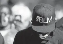  ??  ?? A Black Lives Matter activist bows his head in prayer while participat­ing in Saturday’s march.