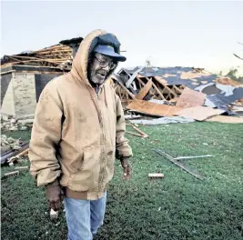  ?? ?? Willie Meeds walks from a relative’s home after helping turn off the house’s water main after a tornado hit in Powderly, Texas, on Saturday.