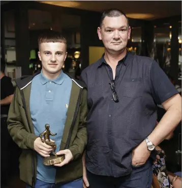  ??  ?? Young Player of the Year award winner Karl Mulligan accepts his award from Ciaran Woodcock at the Enniskerry Youth Club awards at the Powerscour­t Arms.