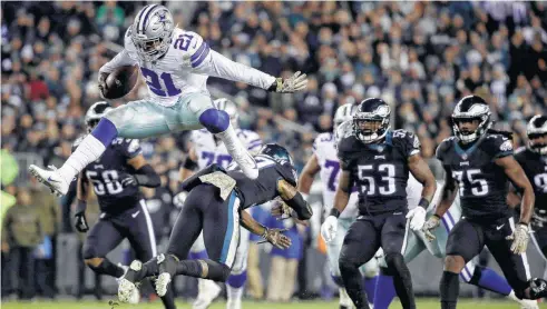  ?? Matt Rourke / Associated Press ?? Cowboys running back Ezekiel Elliott hurdles over Eagles defensive back Tre Sullivan during the first half. Elliott had 151 yards and a touchdown rushing on 19 carries and he added 36 yards and a touchdown on six receptions in the win over Philadealp­hia.