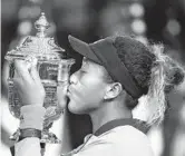  ?? JULIO CORTEZ/AP ?? Boca Raton resident Naomi Osaka kisses the trophy after defeating SerenaWill­iams in last year’s women’s final of the U.S. Open in New York. Osaka is ranked No. 1 heading into the U.S. Open, where she will attempt to defend a Grand Slam title for the first time.