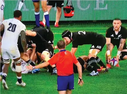  ??  ?? England substitute Courtney Lawes (20) is deemed to be in an offside position moments before blocking the kick of TJ Perenara (right). What could have been a match-winning try from Sam Underhill was subsequent­ly disallowed