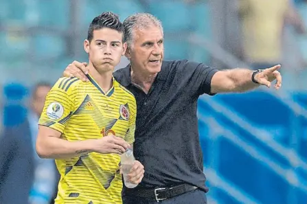  ??  ?? El DT de Colombia, el portugués Carlos Queiroz, da instruccio­nes a James Rodríguez durante el partido contra Paraguay en Copa América.