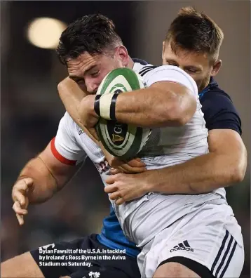  ??  ?? Dylan Fawsitt of the U.S.A. is tackled by Ireland’s Ross Byrne in the Aviva Stadium on Saturday.