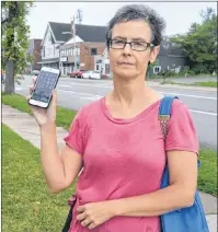  ?? NIKKI SULLIVAN / CAPE BRETON POST ?? Sarah Morrison holds up her cell phone where she has saved text messages from Bell Aliant confirming they said they were waiting on a part to fix issues in the area and that she had informed them of 10 residences with no landline service.