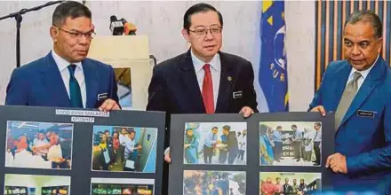  ?? media di Putrajaya, semalam. [FOTO LUQMAN HAKIM ZUBIR/BH] ?? Guan Eng bersama Saifuddin (kiri) menunjukka­n gambar program Food Bank Malaysia pada sidang