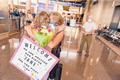  ?? MARK MIRKO PHOTOS/ HARTFORD COURANT ?? Sisters Jane Anderson Holmes, left, and Kim Henn hold each other as the two meet for the first time at Bradley Internatio­nal Airport in Windsor Locks on Thursday after a DNA search revealed their relationsh­ip. Jane was put up for adoption after she was born in Florida to Nancy Cutler, who was 17 at the time.