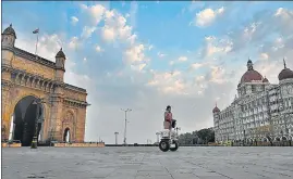  ??  ?? An officer rides a Segway on a deserted lane between the Gateway of India and Taj Mahal Hotel.