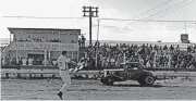  ?? [PHOTO FROM THE MIKE POGUE COLLECTION] ?? Longtime Tulsa Speedway flagman Don Bucy waves the checkers at the end of a race. This photo was shot during an era when some flagmen stood on the edge of the race track.