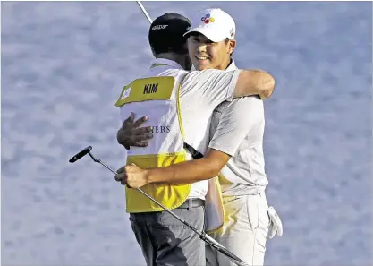  ?? CHRIS O’MEARA / ASSOCIATED PRESS ?? Si Woo Kim of South Korea gets a hug from caddie Mark Carens after winning The Players Championsh­ip with a fifinal round of 3-under 69. Kim was the only player without a bogey on a windy Sunday afternoon at TPC Sawgrass.