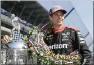  ?? DARRON CUMMINGS — ASSOCIATED PRESS ?? Indianapol­is 500 champion Will Power is photgraphe­d with the Borg-Warner Trophy during the traditiona­l winners photo session on the start/finish line at the Indianapol­is Motor Speedway in Indianapol­is on Monday.