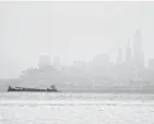  ?? ERIC RISBERG/AP ?? The San Francisco skyline is barely visible through smoke from wildfires Wednesday. Thousands were under orders to evacuate.