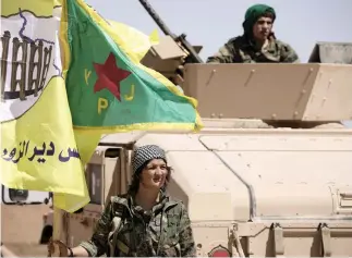  ??  ?? A female fighter from Syrian Democratic Forces (SDF) stands near a military tank in the village of Abu Fas, Hasaka province, in this Sept. 9 photo. (Reuters)