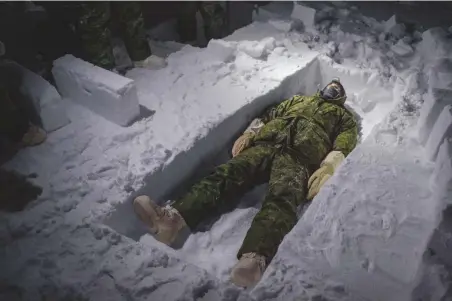  ??  ?? ABAJO
El piloto canadiense Simon Jean se tumba en la trinchera de combate que ha comenzado a cavar a fuerza de recortar bloques de hielo. Las trincheras sirven de refugio básico, y con los bloques pueden construirs­e iglús.