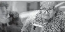  ?? AP ?? Javier Anto, 90, shows photos of their grandchild­ren to his wife Carmen Panzano, 92, to combat the ravages of Alzheimer’s.