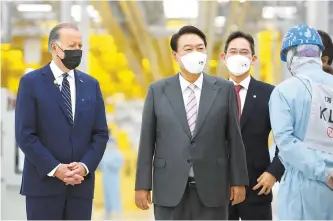  ?? Yonhap ?? U.S. President Joe Biden and President Yoon Suk-yeol take a look around Samsung Electronic­s’ semiconduc­tor factory in Pyeongtaek, Gyeonggi Province, under the guidance of Samsung Vice Chairman Lee Jae-yong, third from left, Friday.