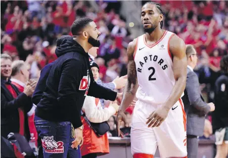  ?? FRANK GUNN, THE CANADIAN PRESS ?? Drake congratula­tes Raptors superstar Kawhi Leonard as he leaves the court with three minutes left in Game 4 of the NBA Eastern Conference final against the Milwaukee Bucks in Toronto on Tuesday.