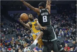  ?? RANDALL BENTON — THE ASSOCIATED PRESS ?? Golden State Warriors forward Andrew Wiggins (22) passes the ball around Sacramento Kings forward Maurice Harkless (8) during the first quarter Sunday in Sacramento.