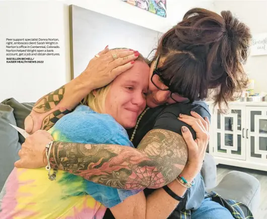  ?? RAE ELLEN BICHELL/ KAISER HEALTH NEWS 2022 ?? Peer support specialist Donna Norton, right, embraces client Sarah Wright in Norton’s office in Centennial, Colorado. Norton helped Wright open a bank account, get a job and obtain dentures.