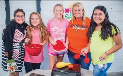  ?? WILLIAM HARVEY/THREE RIVERS EDITION ?? From left, Addie Gillmore, 11, Shaylah Swaim, 12, and Anslee Brewer, 11, stand with their teacher, Lisa Headley, and fellow student Tila Reyes, as they prepare for the upcoming Yum Yum Cooking Club at Central Magnet Elementary School in Batesville....