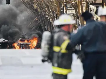  ?? Andrew Nelles The Tennessean ?? A VEHICLE burns after an RV explosion in downtown Nashville early Christmas morning. Authoritie­s say the blast was deliberate, with surveillan­ce video capturing a recorded warning that blared from the RV.