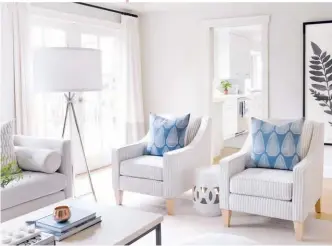  ??  ?? * RIGHT Sunlight bounces
* around the family room,
* which is now a bright and
* welcoming space thanks to a lick of paint, new flooring and light finishes. Custom ARMCHAIRS &
TOSS CUSHIONS, Stephanie Jean Design; STOOL, HomeSense; FLOOR LAMP, Visual Comfort & Co.