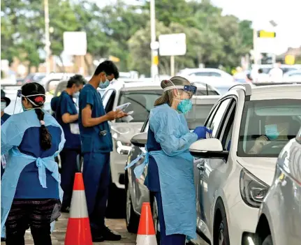 ?? Photo: AAP ?? Health care workers administer COVID-19 PCR tests at the St Vincent’s Drive-through Clinic at Bondi Beach in Sydney, on January 1, 2022.
