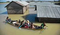  ?? Anupam Nath / Associated Press ?? A family flees with their goats after flooding in India. Climate change is pushing more people out of their homes.