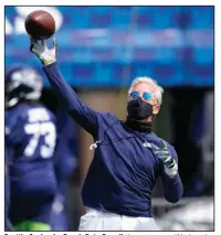  ?? (AP/Ted S. Warren) ?? Seattle Seahawks Coach Pete Carroll throws a pass Wednesday during the Seahawks’ training camp in Renton, Wash. The NFL has implemente­d health protocols to help teams combat covid-19.