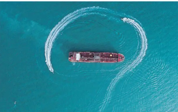  ?? FOTO: DPA ?? Nadelöhr des Welthandel­s: Ein britischer Öltanker wird 2019 in der Straße von Hormus von Booten der iranischen Revolution­sgarden umkreist.