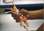  ?? LYNNE SLADKY — THE ASSOCIATED PRESS ?? On May 6, 2019, a drug user deposits used needles into a container at the IDEA exchange in Miami.