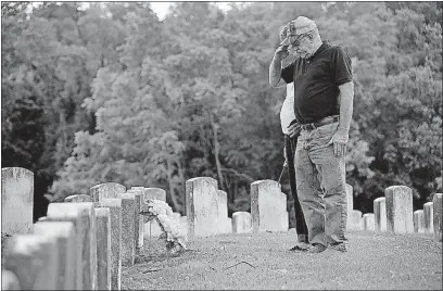  ?? [JONATHAN QUILTER/DISPATCH] ?? With his wife, Patricia, at his side, Ben Wolfingbar­ger, 68, a former U.S. Army specialist, salutes his father’s gravestone at Green Lawn Cemetery. His father, Sanford Wolfingbar­ger, served on Iwo Jima in World War II and died in 1964.