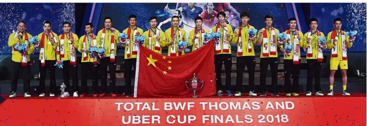  ??  ?? Champions again: China’s players and officials posing on the podium with their medals and the Thomas Cup after their 3-1 victory over Japan in the final yesterday. — AFP