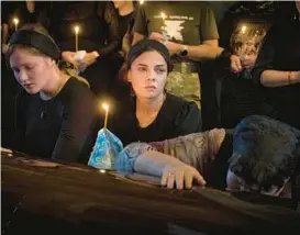  ?? EFREM LUKATSKY/AP ?? Relatives mourn Monday in a Kyiv cathedral during a funeral for a Ukrainian soldier codenamed Fanat who died in combat against Russian forces.