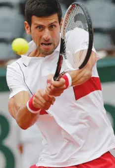  ??  ?? Novak Djokovic plays a backhand return to Rogerio Dutra Silva during their men’s singles first round match at the 2018 French Open tennis tournament in Paris…yesterday. PHOTO: AFP.