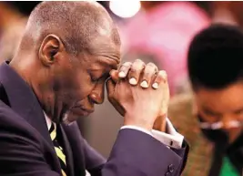  ??  ?? The Rev. George E. Young Sr. prays while an invocation is delivered by the Rev. Puong Ong Lau at Midwest City’s Martin Luther King Jr. Day prayer breakfast.