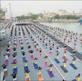  ?? BHUSHAN KOYANDE/HT ?? Navy officials gather in large numbers to participat­e in the yoga day event on the flight deck of Indian Navy's decommissi­oned aircraft carrier Viraat.