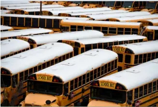  ?? OLIVIER DOULIERYAG­ENCE FRANCE-PRESSE ?? ABOUT 100 school buses are parked at the Arlington County Bus Depot in response to the novel coronaviru­s.