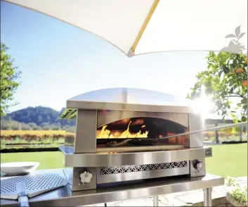  ?? Kalamazoo Outdoor Gourment via AP ?? Top to bottom: Kalamazoo Outdoor Gourmet’s artisan gas-fired pizza oven fired up at a home in Napa, Calif. Pizza ovens can also be used to sear a thick piece of meat or bake items beyond pizza • Kalamazoo Outdoor Gourmet’s hybrid (charcoal, wood and gas) profession­al grill and Arcadia series cabinetry offer indoor kitchen ease in Grand Beach, Mich. • Prepare entire meals outside with Kalamazoo Outdoor Gourmet’s hybrid fire gas grill, refrigerat­ed drawers and 24” double cooktop cabinet as shown in this outdoor space in Chicago, Ill.