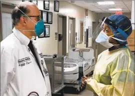  ?? Dr. Charles Powell ?? HEALTHCARE workers Larry Di Fabrizio and Camille Davis at New York’s Mt. Sinai Hospital, which has been inundated with COVID-19 patients.